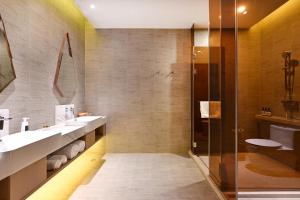 une salle de bain avec deux lavabos et une douche dans l'établissement Atour Hotel Tianjin Eye, à Tianjin 24 autres photos