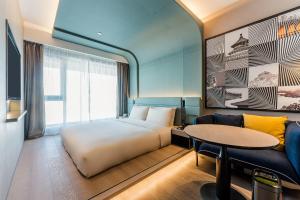 a bedroom with a bed and a couch and a table at Atour S Hotel Beijing Shangdi Qinghe High Speed Railway Station in Beijing