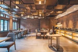 a restaurant with tables and chairs and a brick wall at Atour Hotel Shanghai Pudong Zhangjiang Park in Shanghai