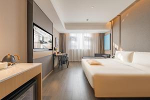 a hotel room with a large bed and a kitchen at Atour Hotel Shanghai Pudong Airport Chuansha Station in Shanghai