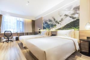 Habitación de hotel con 2 camas y escritorio en Atour Hotel Jinan Zhangqiu Century Avenue, en Jinan