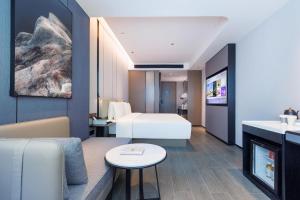 um quarto de hotel com uma cama e uma sala de estar em Atour Hotel Shenzhen Huaqiangbei Commercial Center em Shenzhen