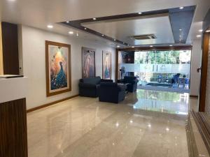 a living room with couches and paintings on the wall at Hotel Heera Residency in Bhopal