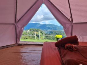 a room with a bed in a tent with a view at อาฉ่างแคมป์ Achang Camp in Mon Jam