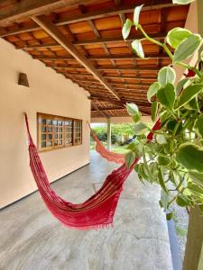 a red hammock in a room with a plant at Casa do sossego in Jijoca de Jericoacoara