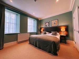 a bedroom with a large bed and two windows at The Georgian, Haslemere, Surrey in Haslemere