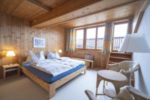 a bedroom with a bed and a table and chairs at Chasa Rontsch Madlaina in Scuol