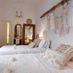 two beds in a bedroom with white walls at Riad CK Medina in Marrakesh