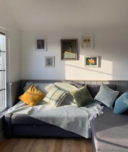 a couch with pillows on it in a living room at Cosy Cabins without hot tub - Greenway Farm, Drybrook, Forest of Dean in Drybrook