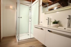 a white bathroom with a shower and a sink at AlbLodges in Bitz