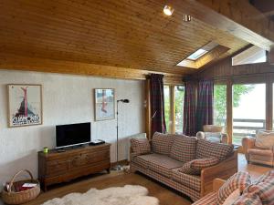 a living room with a couch and a tv at Les Trembles MOUNTAIN & QUIET chalet 12 pers in Veysonnaz