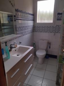 a bathroom with a toilet and a sink and a window at F1 chambre et cuisine in Reynès
