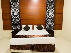 a bedroom with a large bed with a wooden headboard at Beat salsbil hotel in Medina