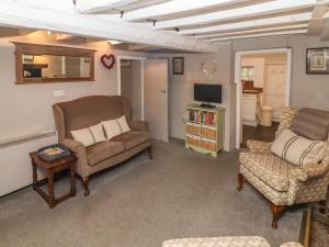 a living room with two couches and a tv at Cosy Cottage in Burford