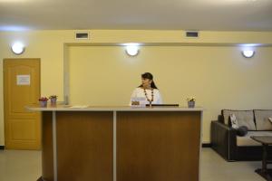 Una mujer parada en un mostrador en una habitación en HOTEL IMERETI TBILISi en Tiflis