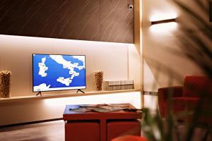 - un salon avec une télévision et une table dans l'établissement Hotel Franciacorta, à Paderno Franciacorta