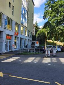 a building with a parking lot next to a street at Bastis Central Guesthouse Lucerne City in Lucerne
