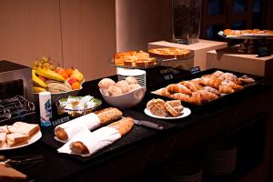 un buffet con varios tipos de pan y bollería en Hotel Franciacorta en Paderno Franciacorta