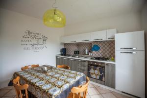 cocina con mesa y nevera blanca en #914 Home - Irpinia, en Nusco