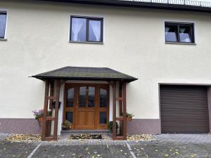 une maison avec une porte en bois et un garage dans l'établissement Westerwaldhaus, 