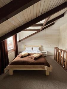 ein Schlafzimmer mit einem großen Bett im Dachgeschoss in der Unterkunft Парк-готель Там, де гори... in Wyschnyzja