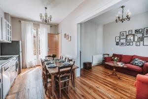 - un salon avec une table et un canapé rouge dans l'établissement Château Belle Epoque - Chambres d'Hôtes & Gîtes, à Linxe