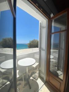 a balcony with a table and a view of the ocean at Fisilanis Beachfront Hotel in Logaras