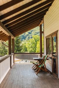 eine Holzterrasse mit einem Tisch und Stühlen darauf in der Unterkunft Парк-готель Там, де гори... in Wyschnyzja