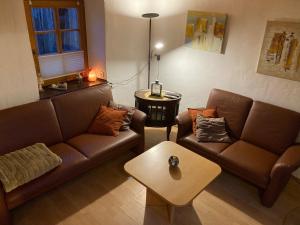 un soggiorno con due divani e un tavolino da caffè di Ferienhaus "Spatzennest" Eifel Gerolstein Hunde ok a Oberbettingen