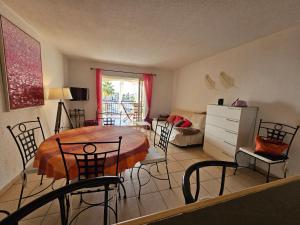 a dining room with a table and chairs in a room at Palmeraie 130- vue mer et village- plage et commerces à pieds in Sari Solenzara
