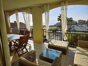 a balcony with a table and chairs and a view at Palmeraie 130- vue mer et village- plage et commerces à pieds in Sari Solenzara
