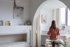 a woman sitting on a chair in a living room looking out a window at Chongqing Forest Design B&B in Chongqing