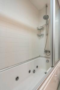 a white bath tub with a shower in a bathroom at Sleek in Istanbul
