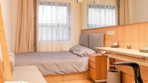 Habitación pequeña con cama y espejo. en Suzhou MeetU Intl Youth Hostel, en Suzhou