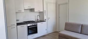 a kitchen with white cabinets and a stove top oven at Maso kreuzberg- Monolocale 3- vista montagne in Trento