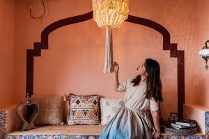 Una mujer con un vestido colgando de una lámpara de araña en Chongqing Forest Design B&B, en Chongqing