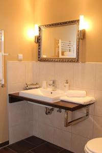 a bathroom with a sink and a mirror at Landgasthof Rieben in Beelitz