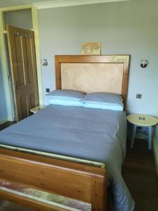 Manston的住宿－Cedar Top，一间卧室配有一张带木制床头板和一张桌子的床。