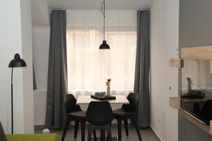 uma mesa de jantar com cadeiras pretas e uma janela em Maks Osijek em Osijek