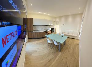 a kitchen and living room with a blue table and chairs at Attici Alba e Tramonto in Brescia