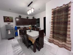 eine Küche mit einem Tisch mit Stühlen und einem Kühlschrank in der Unterkunft Casa Via: Cozy 3 Bedroom Home in Bacolod with Parking in Bacolod City