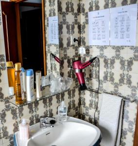 a bathroom with a sink and a red lamp on the wall at Alminhas House in Alapela