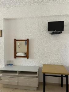 Pokój z telewizorem, stołem i lustrem w obiekcie Yannis Apartments Barbati w mieście Barbati
