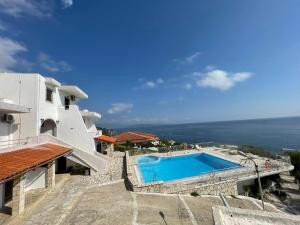 a villa with a swimming pool next to the ocean at Yannis Apartments Barbati in Barbati