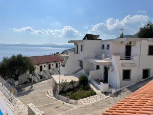 a group of white buildings with the ocean in the background at Yannis Apartments Barbati in Barbati