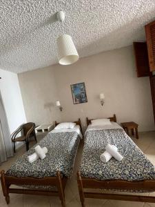 two beds sitting in a room with at Yannis Apartments Barbati in Barbati +22 photos