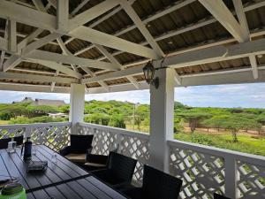 une terrasse couverte avec des chaises, une table et un plafond en bois dans l'établissement Ras Kitao Holiday Villa, à Lamu