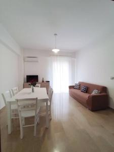 ein Wohnzimmer mit einem Tisch und einem Sofa in der Unterkunft White Sea - Luminoso Appartamento a 200mt dal mare in Spadafora