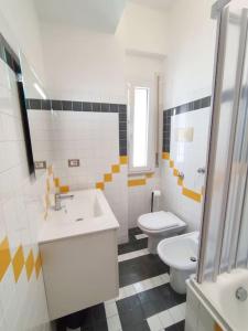 ein Bad mit einem WC und einem Waschbecken in der Unterkunft White Sea - Luminoso Appartamento a 200mt dal mare in Spadafora