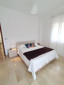 a white bedroom with a large white bed in a room at White Sea - Luminoso Appartamento a 200mt dal mare in Spadafora